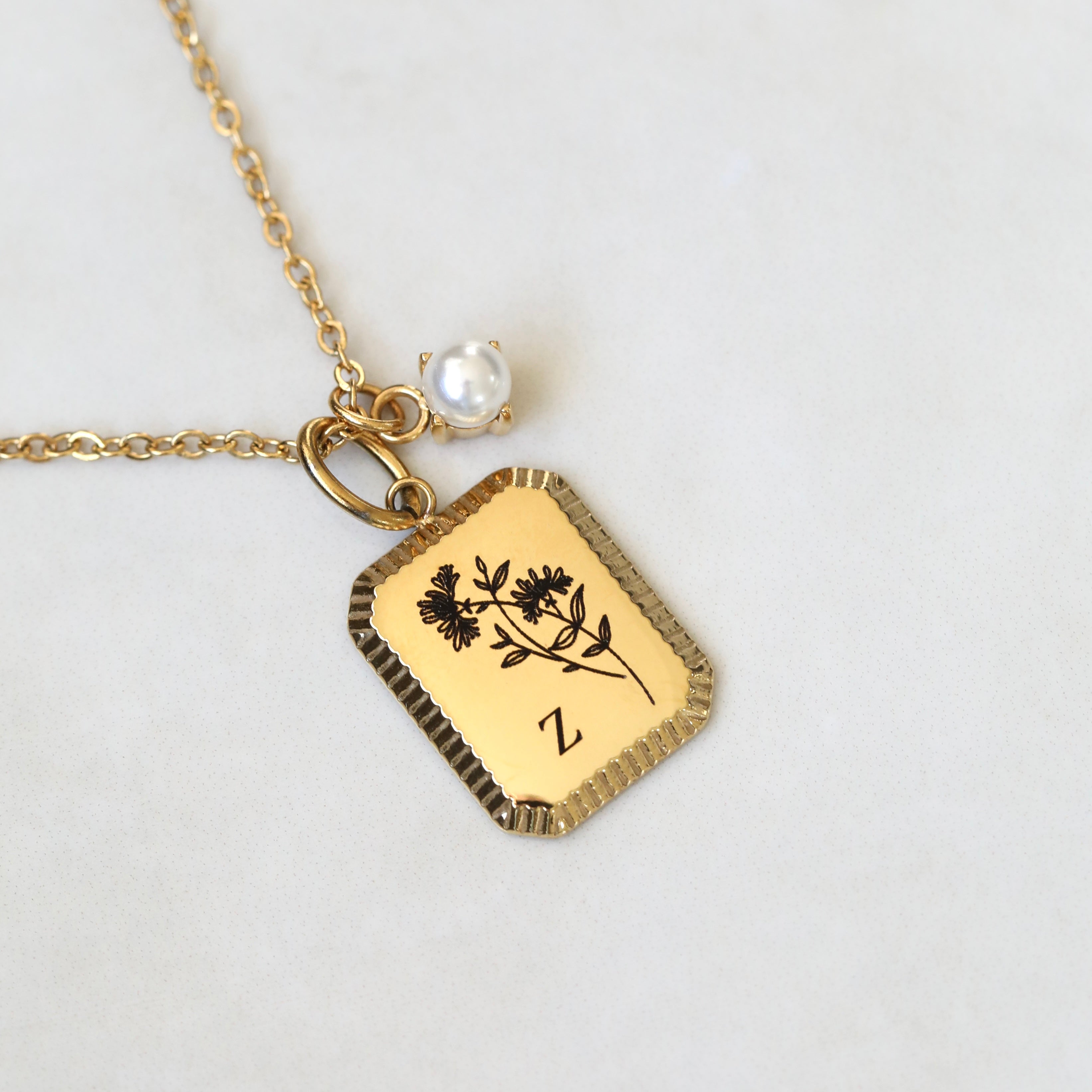 Gold necklace with a detailed edge pendant featuring a June birth flower and letter 'Z' initial design with a pearl birth stone.